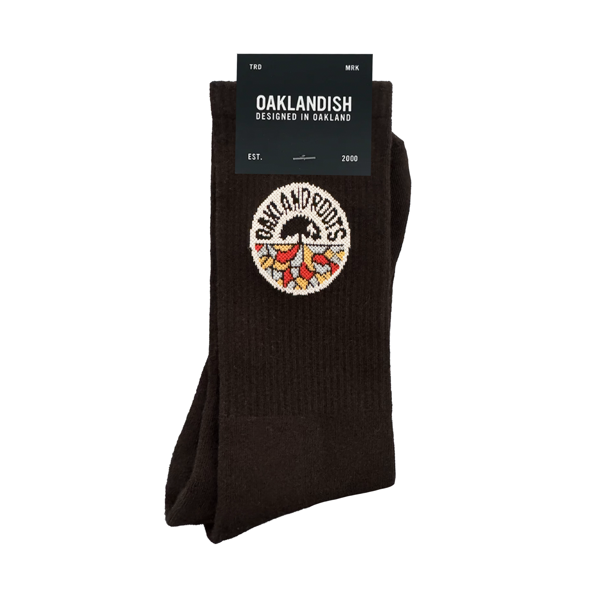 The Roots SC Socks by Oakland Roots SC are black cotton crew socks with a colorful tree and roots embroidered patch. The label reads "OAKLANDISH Designed in Oakland," “one size fits most,” and includes "EST. 2000" on the packaging.