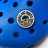 Oakland Roots SC crest pvc shoe charm modeled on blue clogs.
