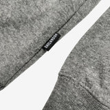 Close up of small Oaklandish wordmark tag on the side of a gunmetal heather hoodie.